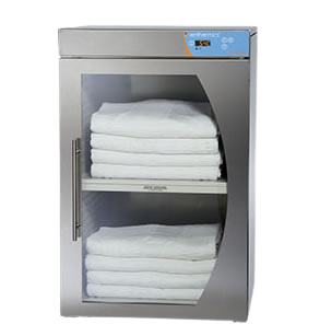 Stack of white towels inside a stainless steel towel warmer with a digital display on a white background.