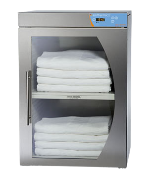 Stainless steel towel warmer with folded white towels inside on a white background